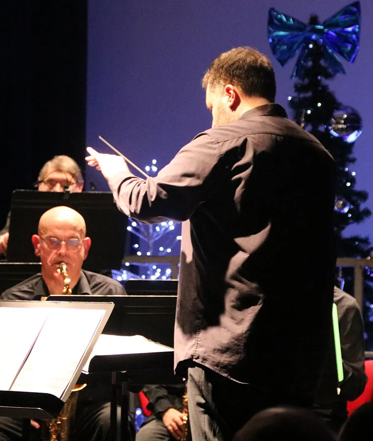 Chef d’orchestre dirigeant devant le pupitre de saxophone — concert de Sainte-Cécile du 7 décembre 2025 à Golbey