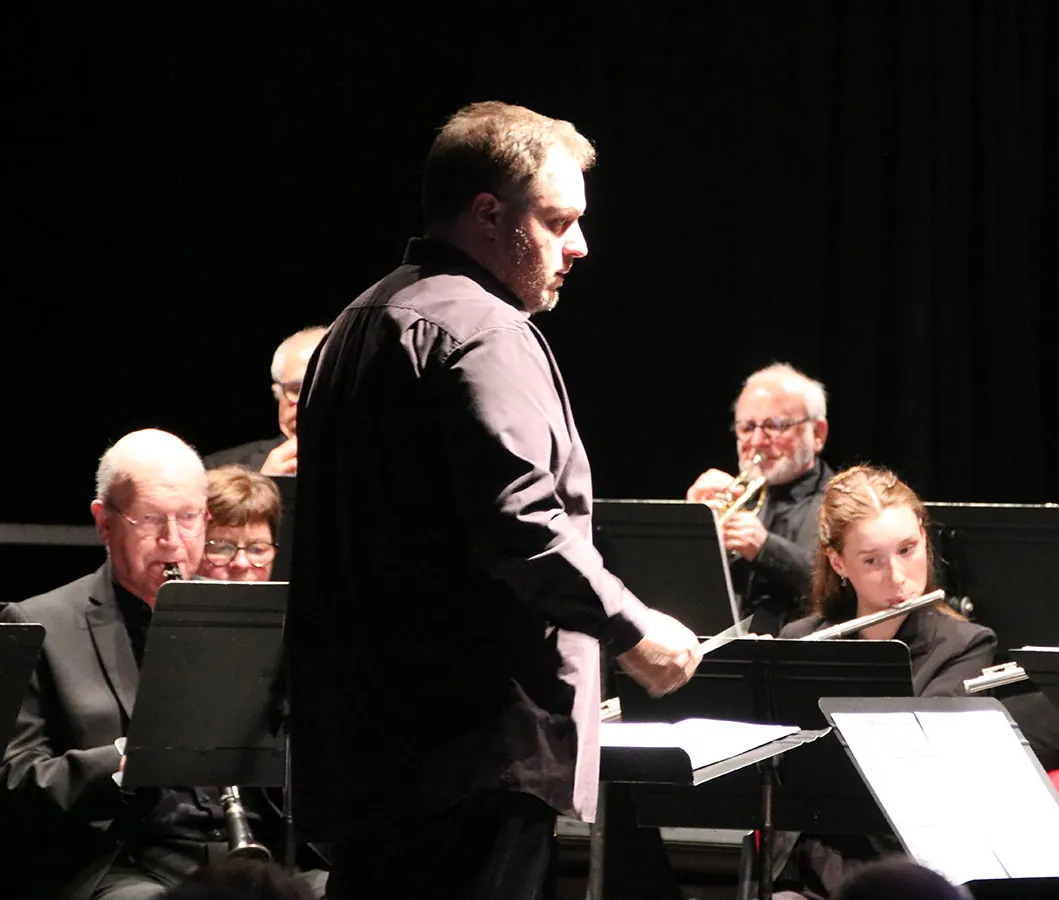 Chef d’orchestre dirigeant devant le pupitre de flûte traversière — concert de Sainte-Cécile du 7 décembre 2025 à Golbey