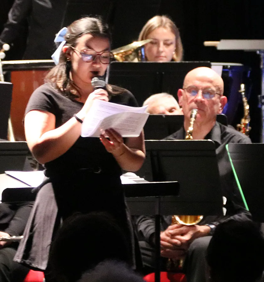 Intervenante lisant un texte devant l’orchestre pendant le concert de Sainte-Cécile 2025 à Golbey