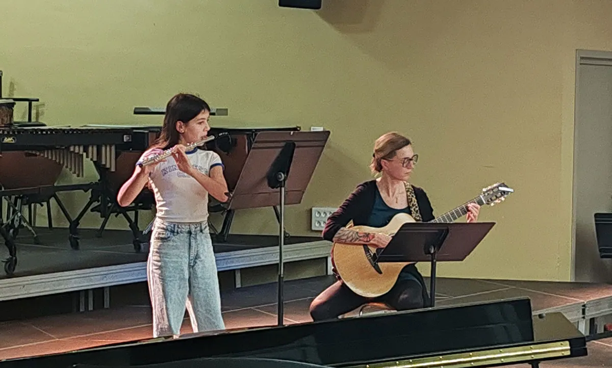 Musiciens jouant de la guitare et de la flûte traversière dans le même cadrage — auditions du 12 décembre 2025 à l’École de musique de Golbey