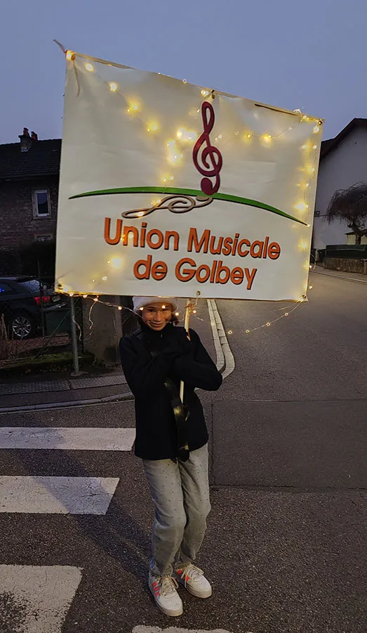 Porte-bannière de l’Union Musicale de Golbey ouvrant la parade de Noël du 13 décembre 2025