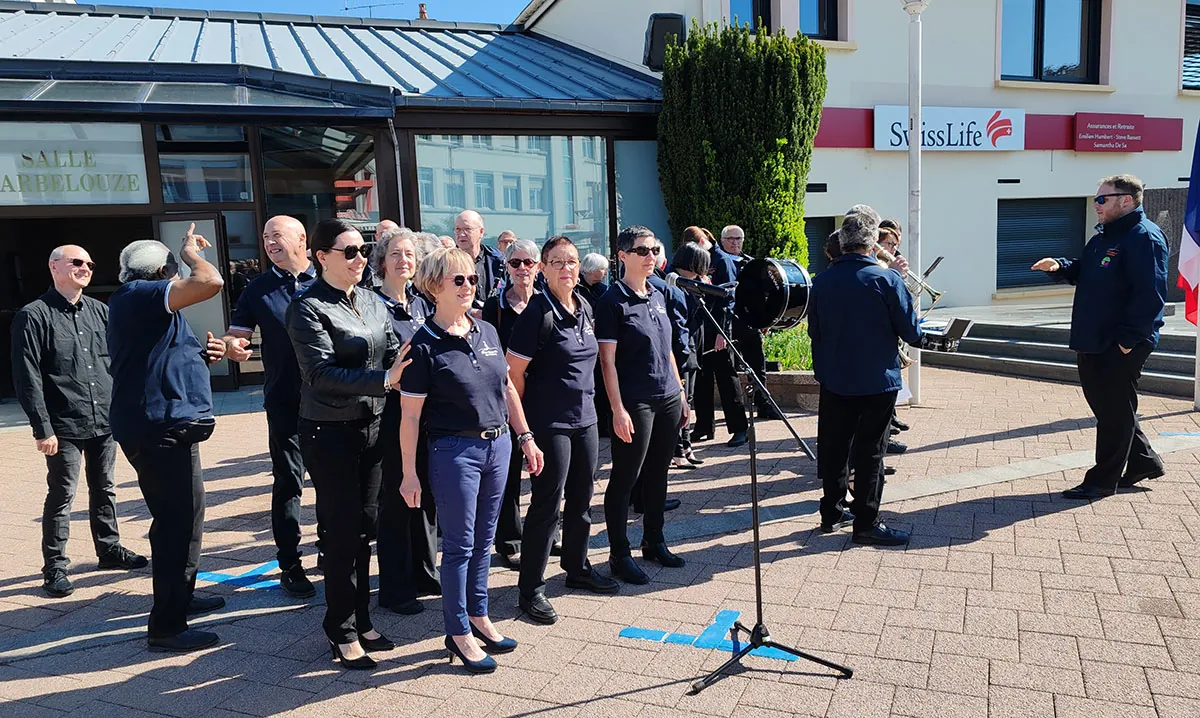 Chorale Coup de Chœur chantant devant l’orchestre pendant la cérémonie du 8-Mai 2026 à Golbey