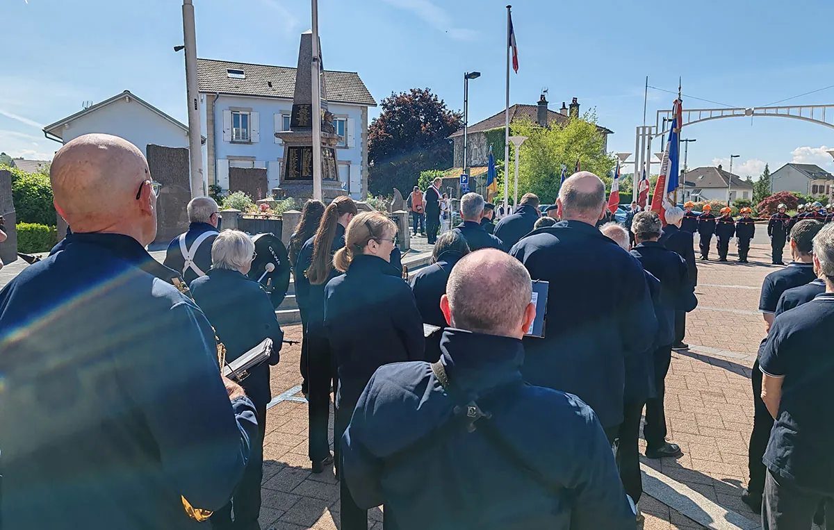 Orchestre réuni sur scène autour du chef — cérémonie du 8-Mai 2026 à Golbey