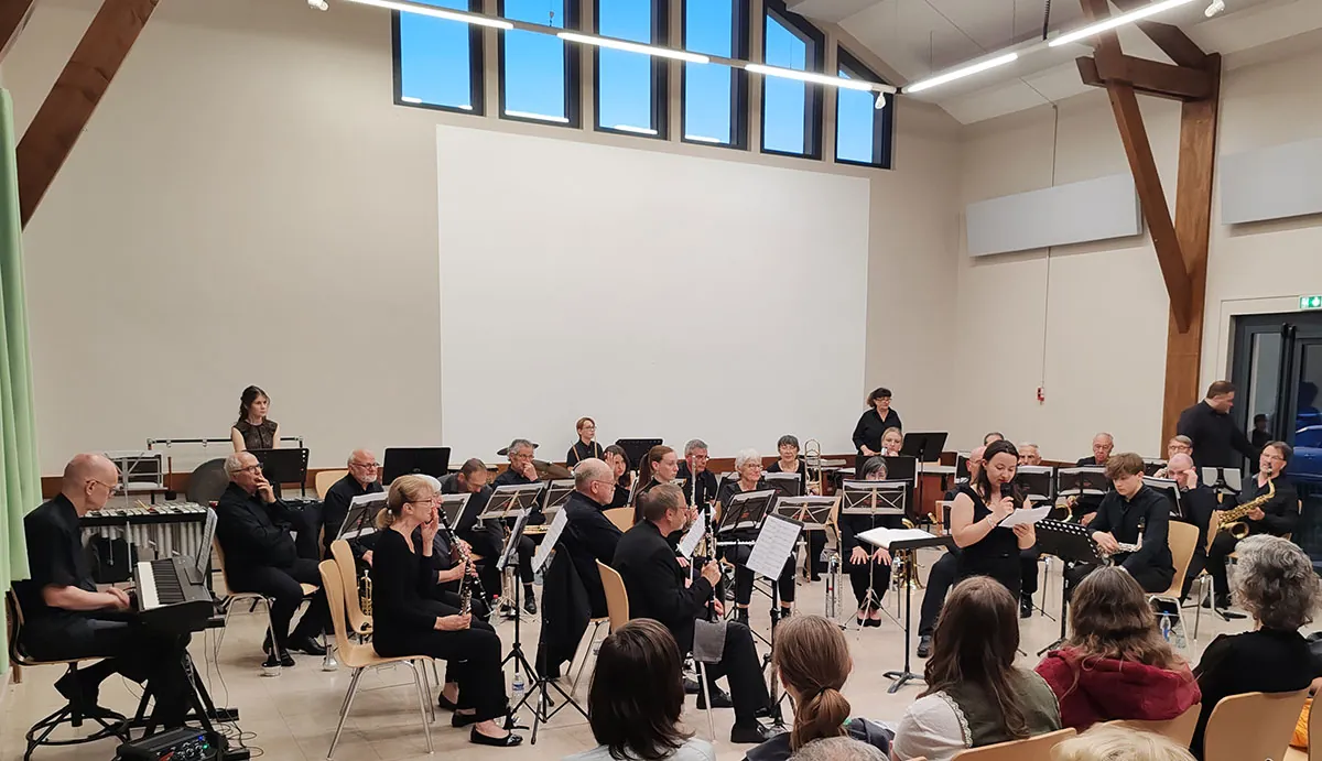 Conteuse intervenant devant l’orchestre et le public — concert de printemps du 9 mai 2026 à Uxegney