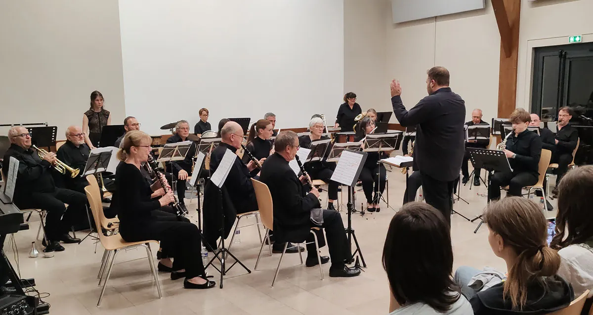 Orchestre réuni sur scène autour du chef — concert de printemps du 9 mai 2026 à Uxegney