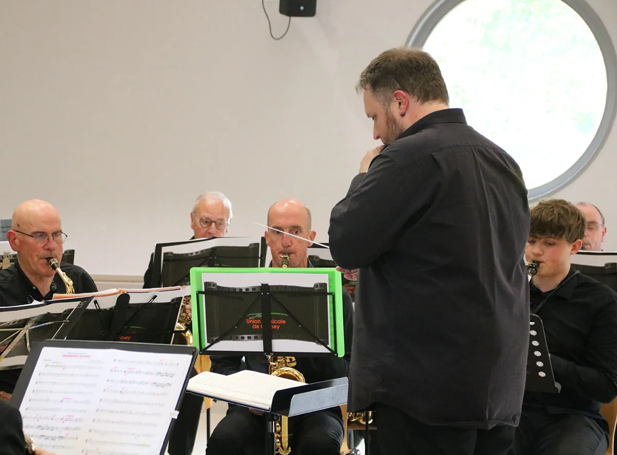 Chef d’orchestre dirigeant devant le pupitre de saxophones — concert de printemps du 17 mai 2026 à Jeuxey