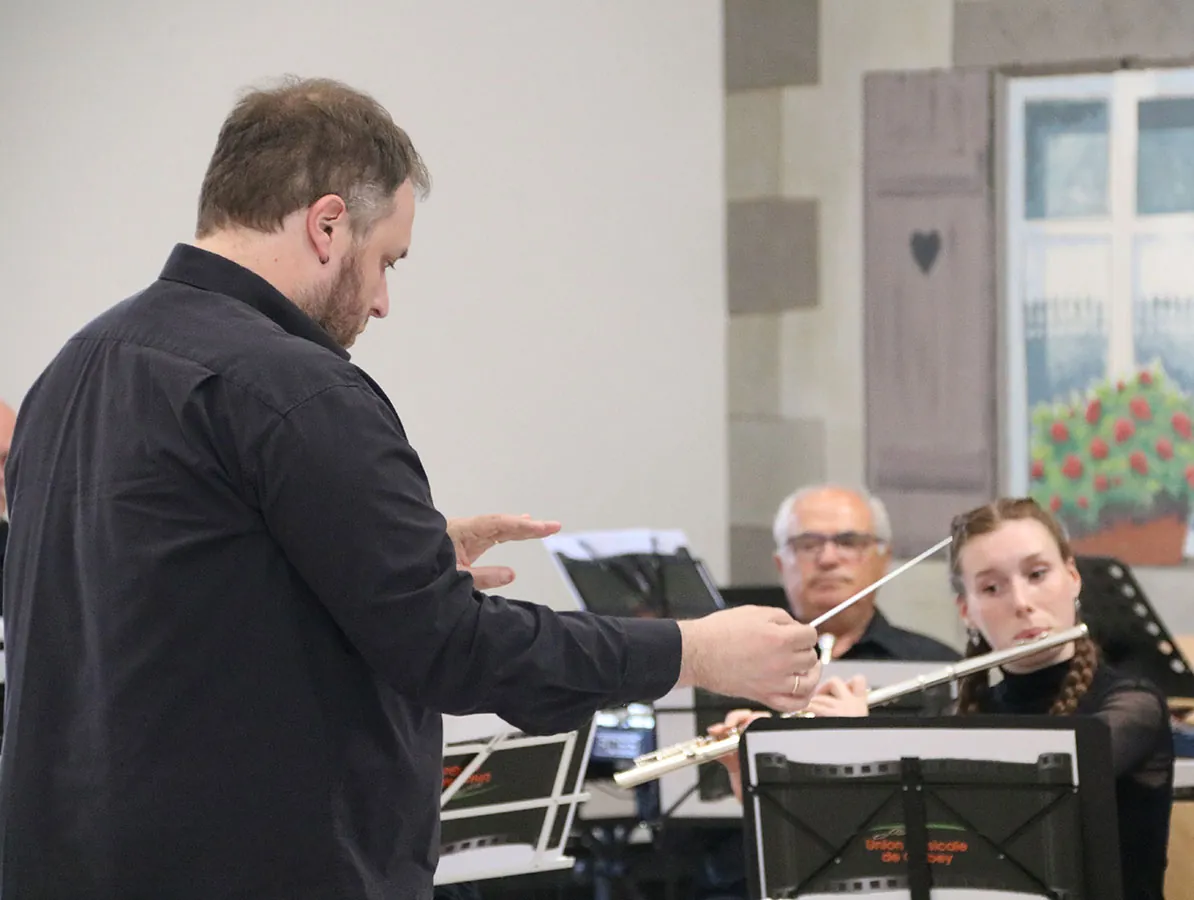 Chef d’orchestre dirigeant devant le pupitre de flûte traversière — concert de printemps du 17 mai 2026 à Jeuxey