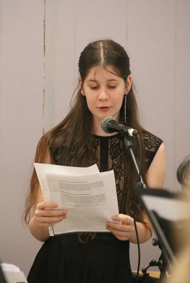 Jeune intervenante lisant un texte au microphone devant l’orchestre — concert de printemps du 17 mai 2026 à Jeuxey