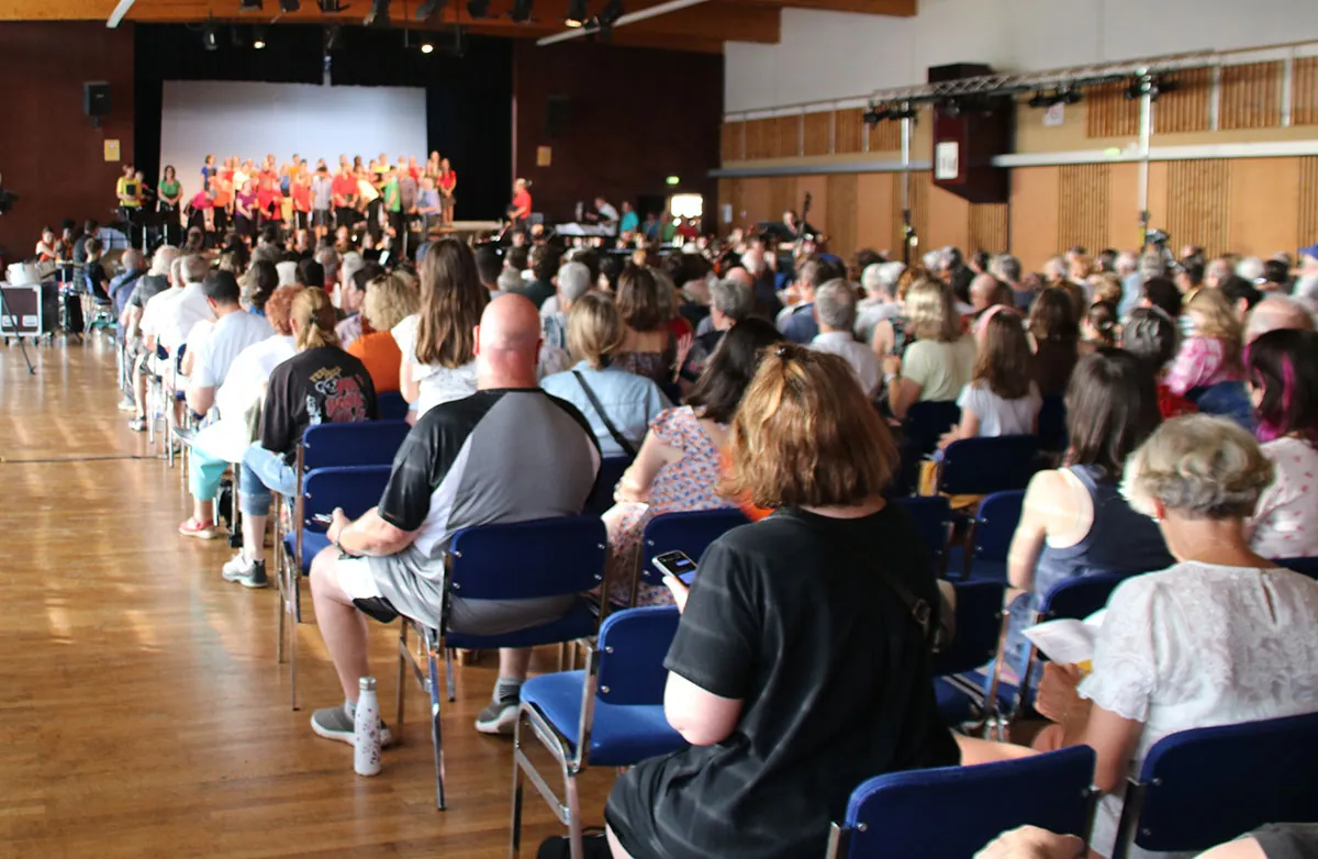 Public assis face à la chorale Coup de Chœur et à l’ensemble instrumental réunis pour Dogora — concert Dogora du 30 mai 2026 à Contrexéville