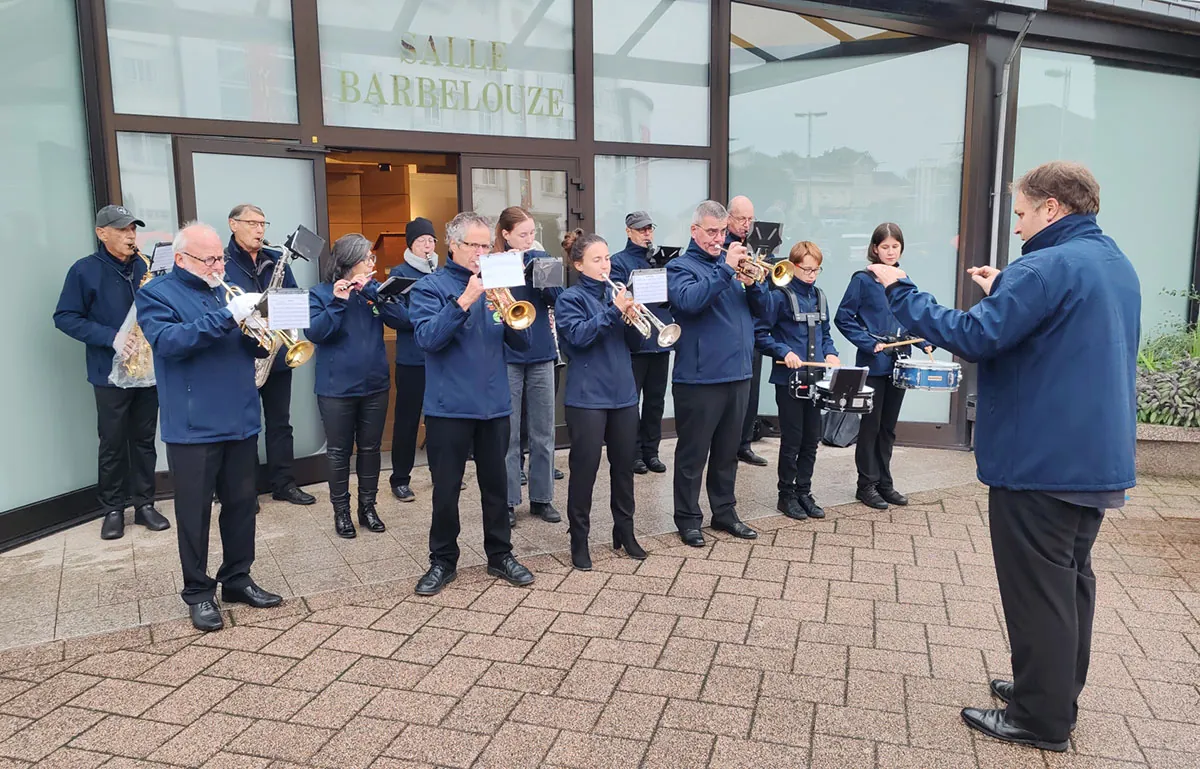 Un petit ensemble de l’harmonie jouant devant un bâtiment sous la direction du chef — la cérémonie commémorative de la Libération, 23 septembre 2025