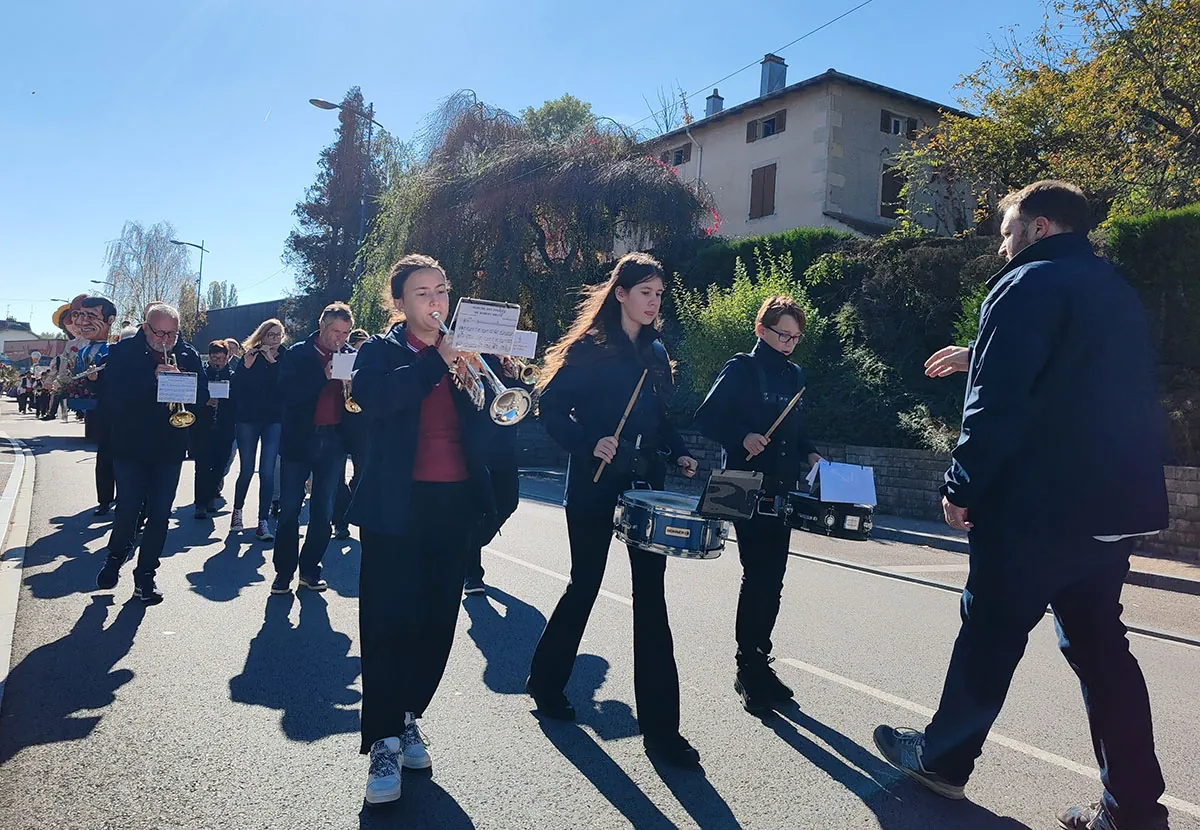 Les musiciens de l’harmonie avançant dans le défilé, derrière les pupitres — le défilé de la fête de Sainte-Fleur, 11 octobre 2025