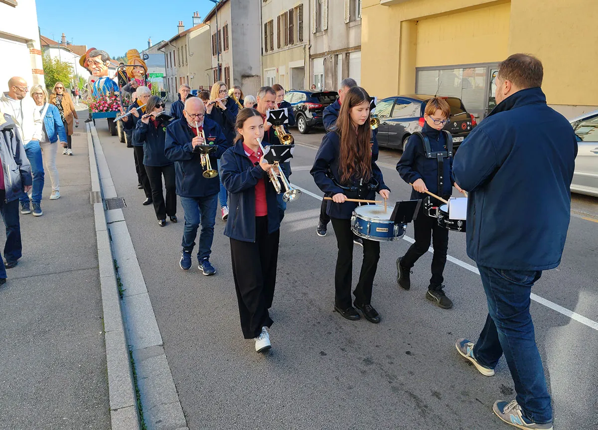 Les musiciens de l’harmonie avançant dans le défilé, vu depuis le public — le défilé de la fête de Sainte-Fleur, 11 octobre 2025