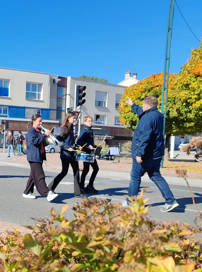 De jeunes musiciens de l’harmonie marchant et jouant en formation, pendant l’interprétation — le défilé de la fête de Sainte-Fleur, 11 octobre 2025