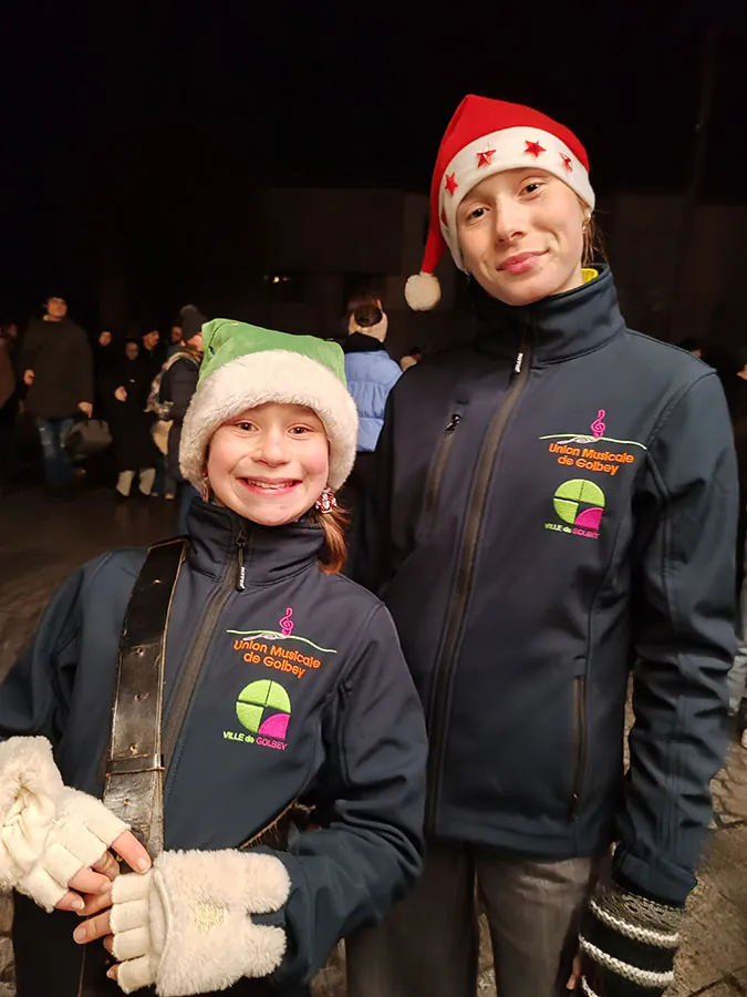 Deux jeunes membres de l’Union Musicale de Golbey en tenue de défilé et bonnet de Noël — le défilé de Saint-Nicolas, 6 décembre 2025
