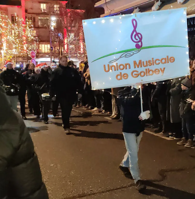 Un porte-bannière de l’Union Musicale de Golbey ouvrant le cortège — le défilé de Saint-Nicolas, 6 décembre 2025