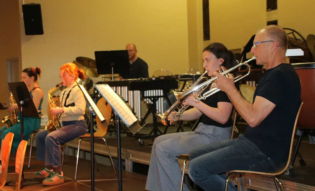 Une classe d’orchestre d’élèves jouant sous la direction d’une adulte, vu depuis le public — 10 avril 2026
