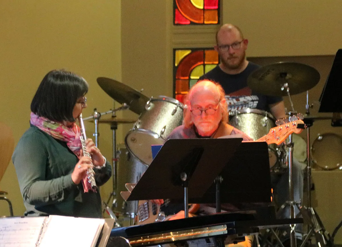Une flûtiste jouant avec un bassiste et un percussionniste pendant la jam session — une jam session de l’atelier jazz, 19 mai 2026