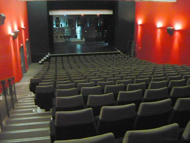 La salle de spectacle de l’Alhambra de Vittel vide, vue depuis le fond vers l’écran ou la scène — une vue de la salle de spectacle vide