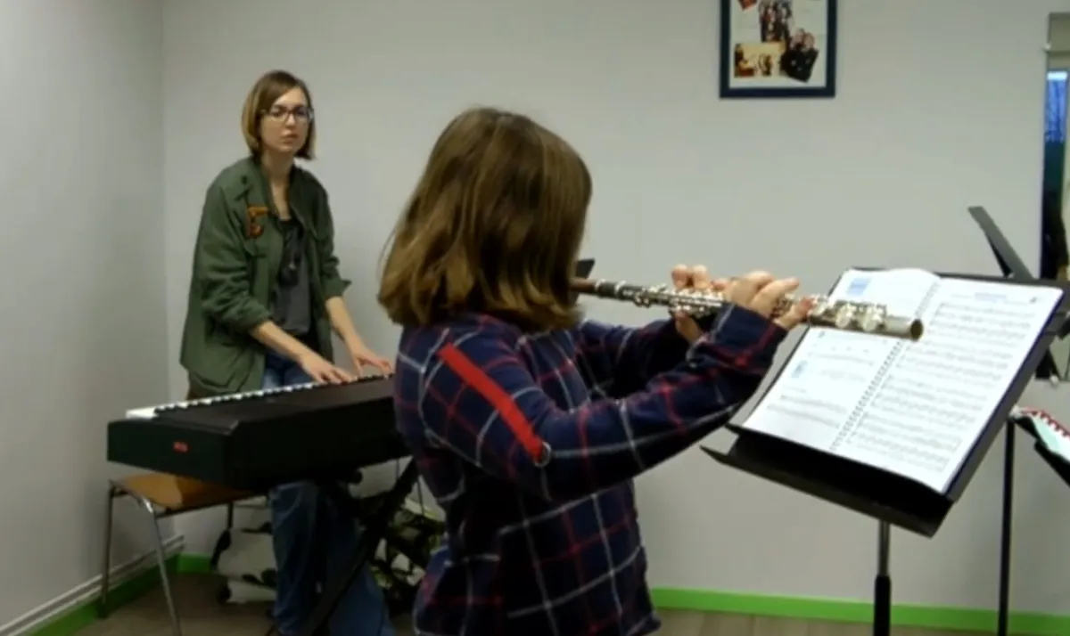 Élève de flûte traversière jouant avec sa professeure au piano