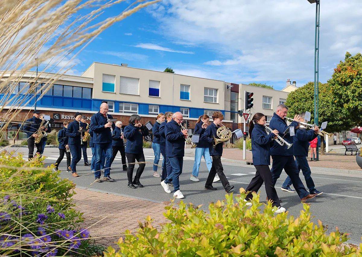 Vue d'ensemble de musiciens de l'Union Musicale de Golbey en formation dans la rue pendant le défilé de la Sainte-Fleur à Golbey