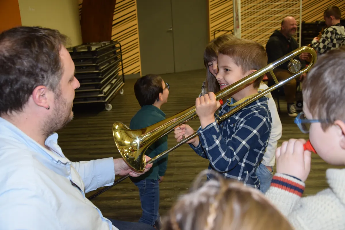 Jeune élève essayant un trombone avec son professeur