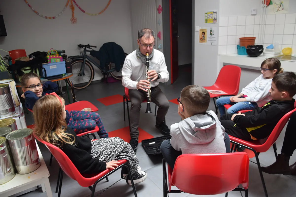 Professeur présentant la clarinette à un groupe de jeunes élèves
