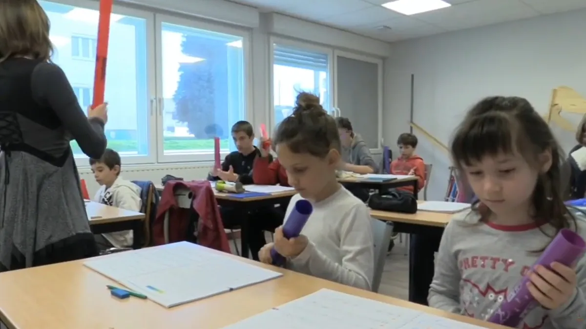 Deux jeunes élèves utilisant des accessoires rythmiques pendant un cours de formation musicale