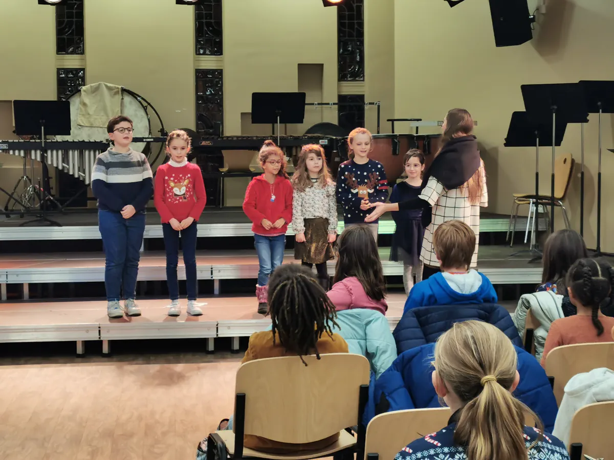 Petit groupe d’enfants chantant sur scène lors d’une audition