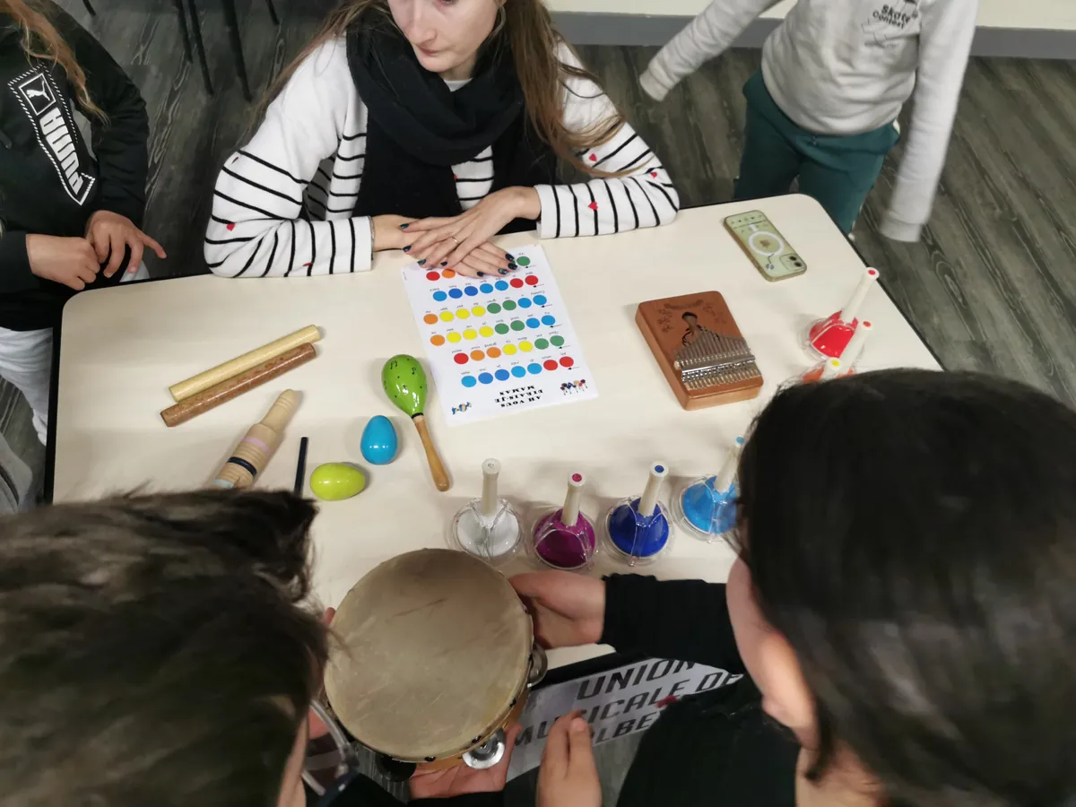 Atelier de découverte des percussions avec plusieurs enfants autour d’une table