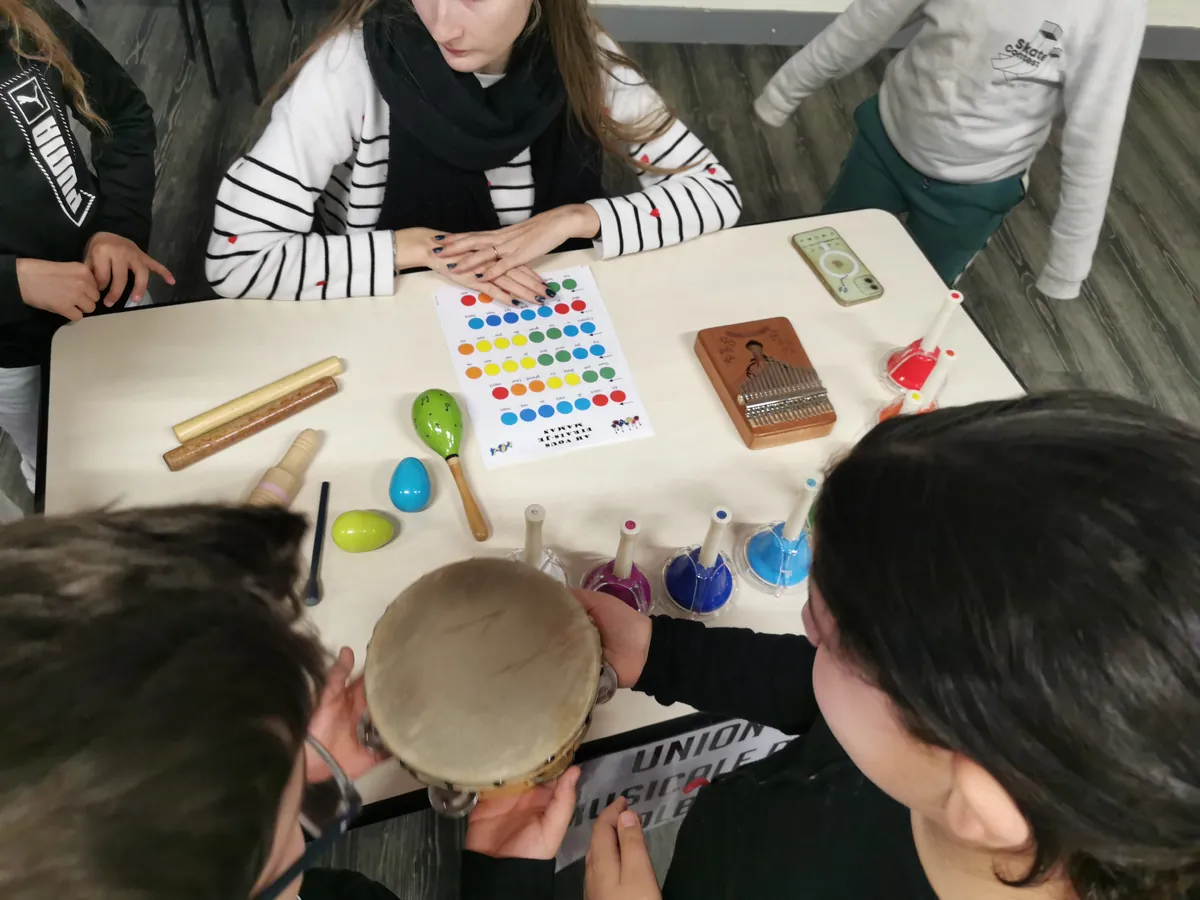 Jeunes élèves manipulant des instruments de percussion pendant un atelier musical