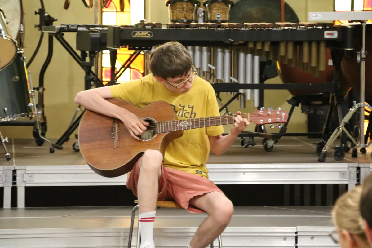 Jeune guitariste jouant seul sur scène lors d’une audition